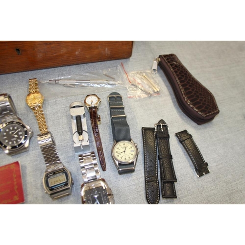 395 - An oak box containing a selection of modern ladies and gentlemen's wristwatches, spares, etc and a s... 