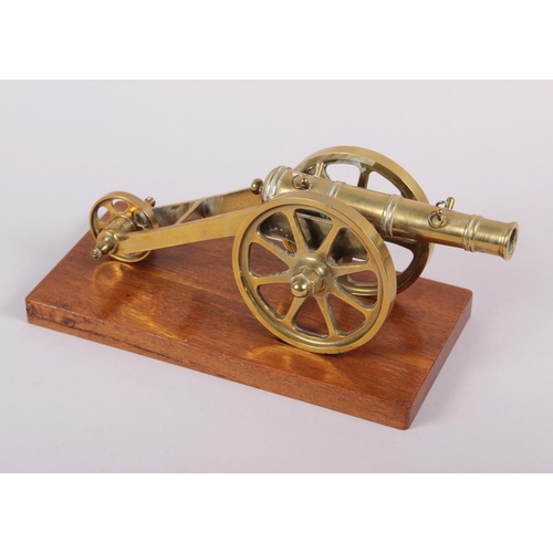 125 - A brass model of a cannon and a three wheeled carriage