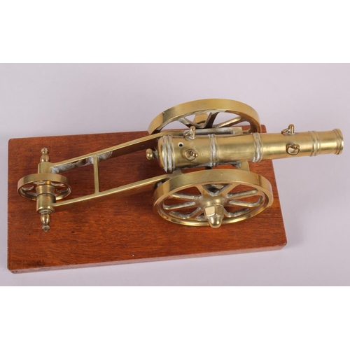 125 - A brass model of a cannon and a three wheeled carriage