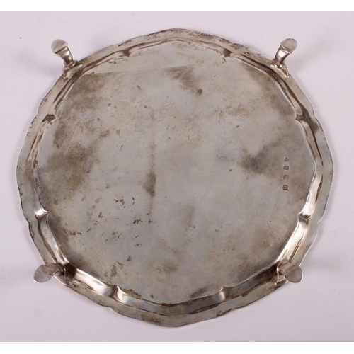 254 - A silver pie crust salver, raised on four hoof feet, 8