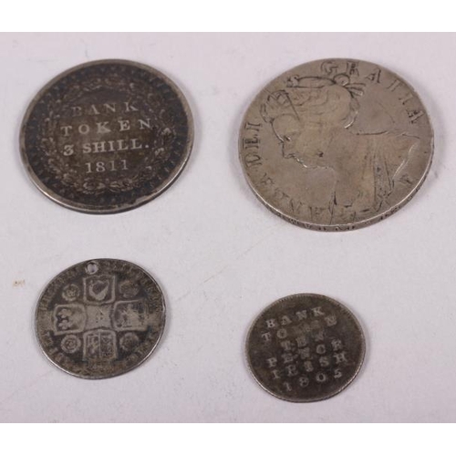 304 - A Queen Anne silver crown, dated 1707, a George II silver shilling, dated 1745 (holed), a George III... 