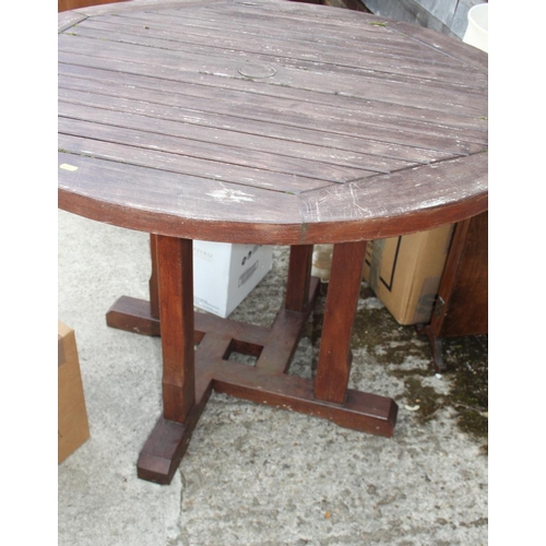 673 - A wooden circular slatted garden table, 41