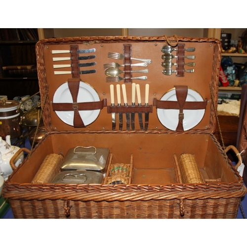 185 - An early 20th century wickerwork picnic basket with part fitted interior, tin plates, cutlery, stora... 