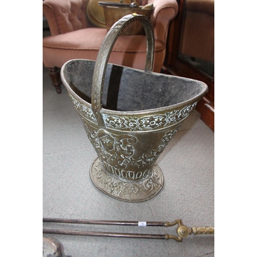 112 - An embossed brass coal bucket and a set of steel fire irons with cast brass handles