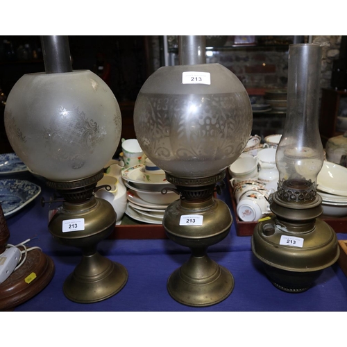 229 - Three brass oil lamps, one shade and two chimneys