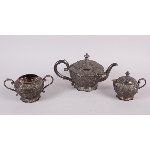 313 - An Oriental white metal three-piece teaset with embossed decoration, 30.7oz troy approx (dent to han... 