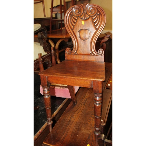 522 - A George IV carved mahogany hall chair with scroll back and panel seat, on turned supports