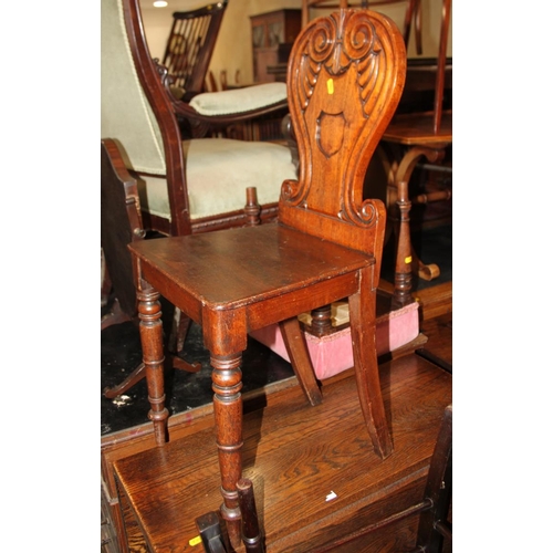 522 - A George IV carved mahogany hall chair with scroll back and panel seat, on turned supports