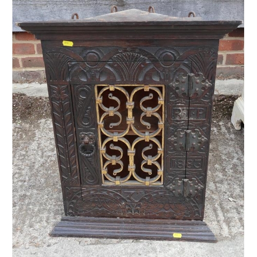 534 - A 19th century carved oak corner cupboard, inscribed RTP 1883, with wrought iron grille door, 20