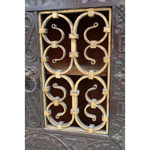 534 - A 19th century carved oak corner cupboard, inscribed RTP 1883, with wrought iron grille door, 20