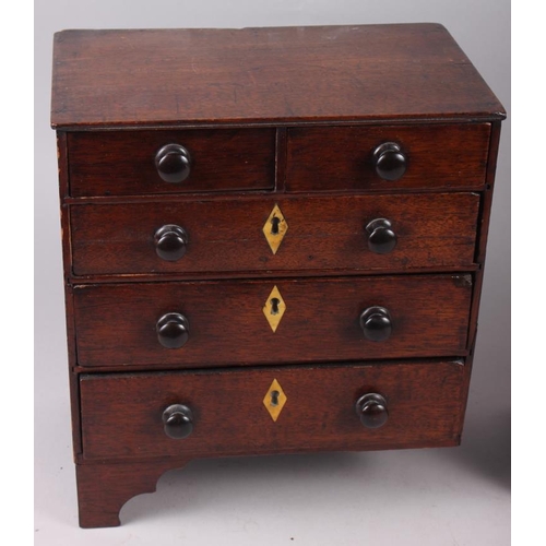 165 - A 19th century miniature chest of two short and three long drawers, on bracket supports, 10