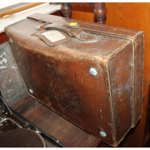 213 - An HMV portable gramophone, in black case, and a brown leather suitcase