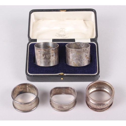 293 - A cased pair of mid 20th century silver napkin rings, engraved initials and dated, and three other s... 