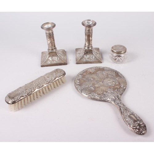 315 - A pair of squat silver candlesticks embossed cherubs' heads, and a similar hand mirror, pin jar and ... 