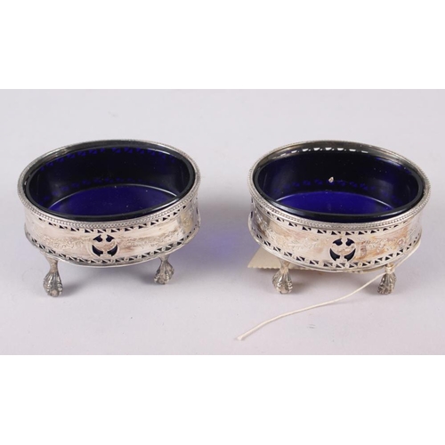 319 - A pair of George III oval silver salts with pierced sides engraved swags, on ball and claw supports,... 