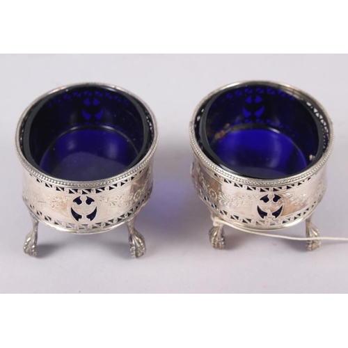 319 - A pair of George III oval silver salts with pierced sides engraved swags, on ball and claw supports,... 