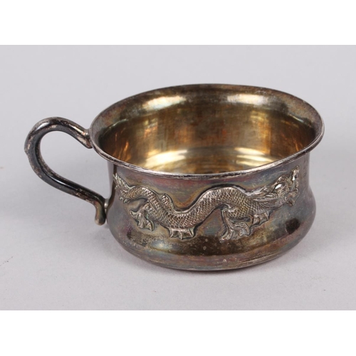 321 - A Chinese shallow white metal cup, decorated dragon, two silver dishes, inset coins, and two silver ... 