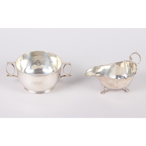 322 - A two-handled silver porringer, engraved initials, and a silver sauce boat with cut edge, 7oz troy a... 