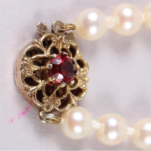 336 - A string of graduated cultured pearls with 9ct gold and garnet clasp, 20 1/2