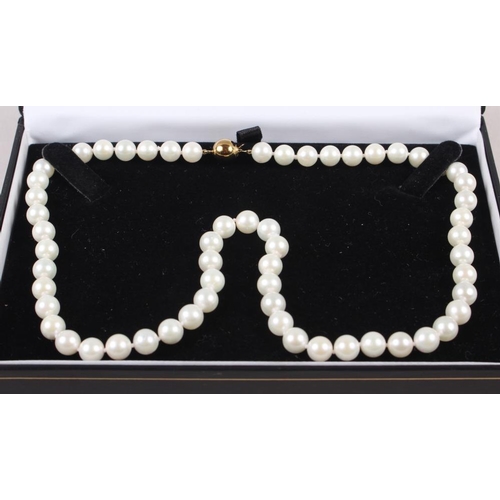 341 - A string of uniform cultured pearls with yellow metal globular clasp, stamped 375, 17 1/22 long