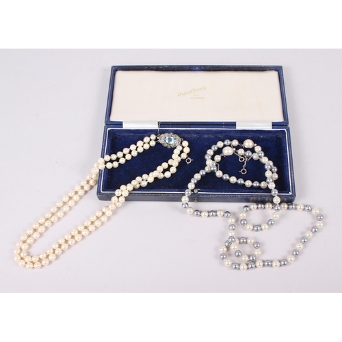 350 - A two strand pearl necklace with sterling silver clasp set blue stone and another two-colour pearl n... 