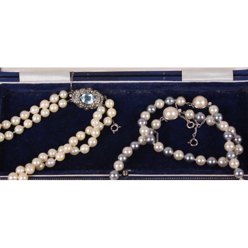 350 - A two strand pearl necklace with sterling silver clasp set blue stone and another two-colour pearl n... 