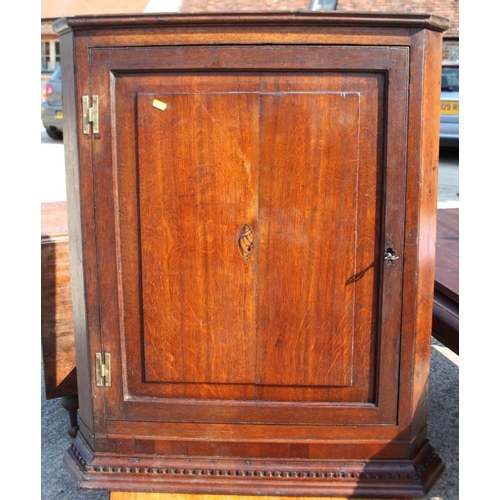 517 - A Georgian oak wall corner cabinet with panelled door inlaid shell, 30