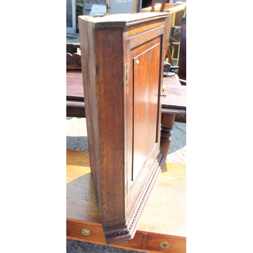 517 - A Georgian oak wall corner cabinet with panelled door inlaid shell, 30