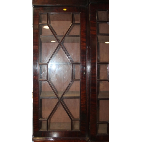 520 - An early 19th century mahogany breakfront library bookcase, fitted astragal beaded glazed doors, bas... 