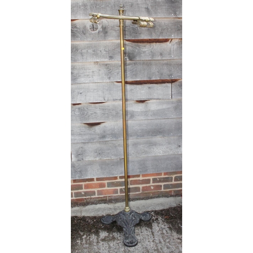 567 - A Victorian brass stand with revolving top, fitted hooks, on triangular black cast iron base, 69