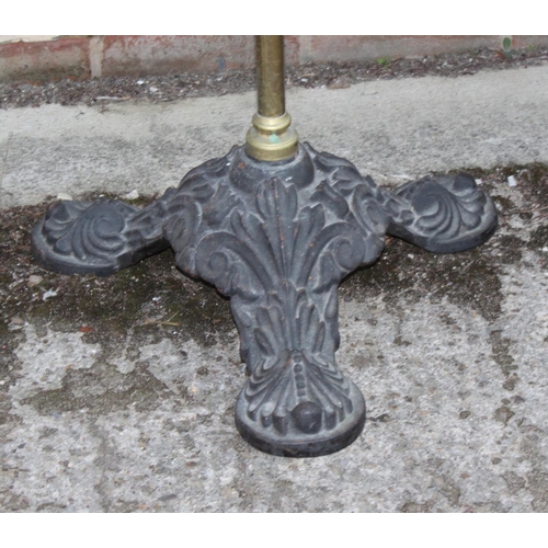 567 - A Victorian brass stand with revolving top, fitted hooks, on triangular black cast iron base, 69