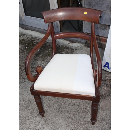 574 - An early 19th century mahogany rail back carver chair with scroll arms, on turned octagonal supports