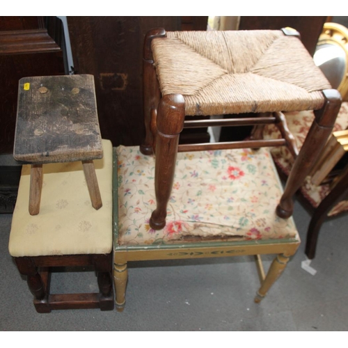 600 - An oak framed stool, upholstered in a yellow fabric, a cane seat stool, a cream painted stool and on... 