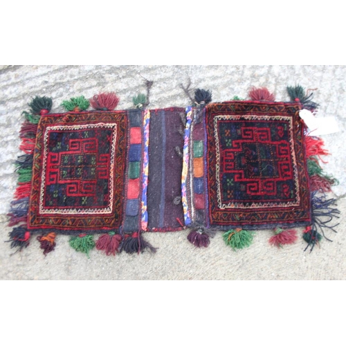 734 - A Caucasian saddle bag decorated square hooked medallion on a red ground, 32