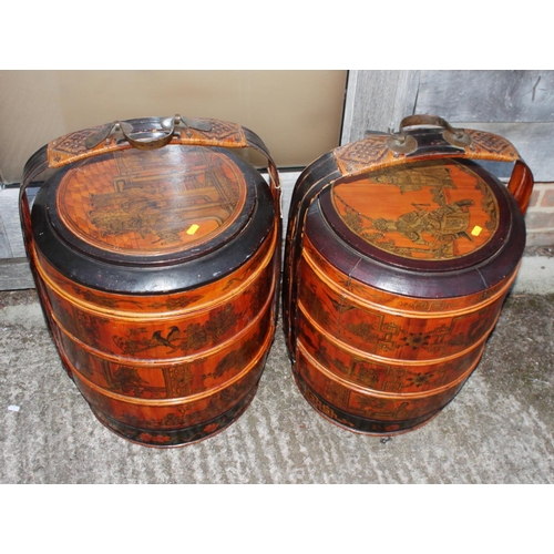 91 - A pair of Chinese lacquered four-tier wedding baskets, decorated panels with figures and fruit, 25