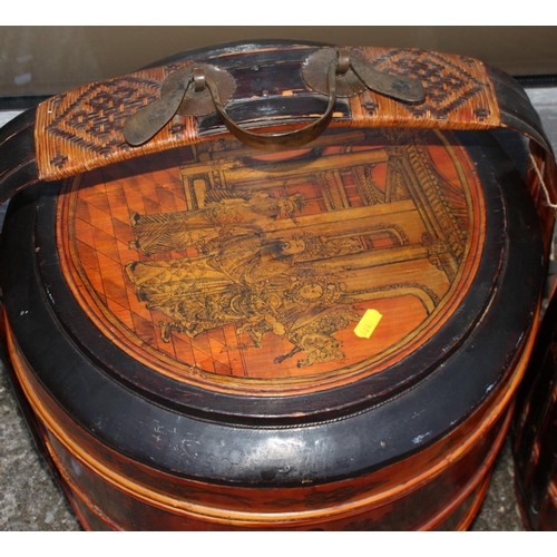 91 - A pair of Chinese lacquered four-tier wedding baskets, decorated panels with figures and fruit, 25