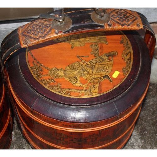 91 - A pair of Chinese lacquered four-tier wedding baskets, decorated panels with figures and fruit, 25