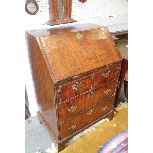 543 - An early 18th century crossbanded walnut bureau with stepped interior and two short and two long dra... 