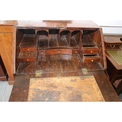 543 - An early 18th century crossbanded walnut bureau with stepped interior and two short and two long dra... 