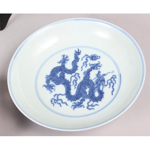 69 - Two Chinese blue and white dragon decorated dishes with six character marks to bases, similar plates... 