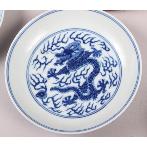 69 - Two Chinese blue and white dragon decorated dishes with six character marks to bases, similar plates... 