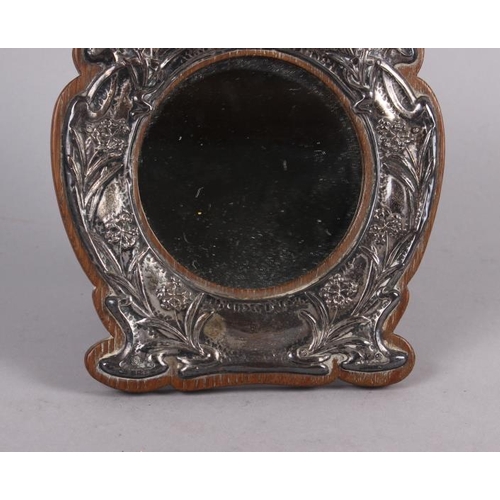 314 - An Edwardian silver faced oak strut mirror, embossed 