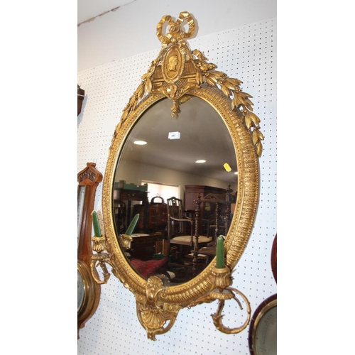 595 - A 19th century oval gilt framed girandole with ornate ribbon and husk surmount, fitted two candlehol... 