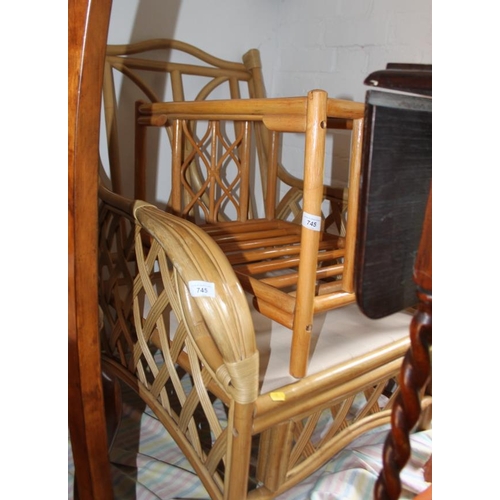 745 - A cane framed garden armchair and a similar glass topped coffee table