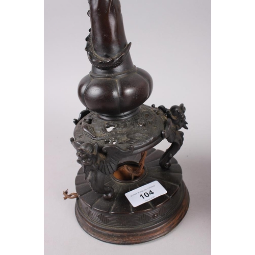 104 - A pair of Chinese bronze table lamps with relief dragon decoration, on circular bases, 17 1/2