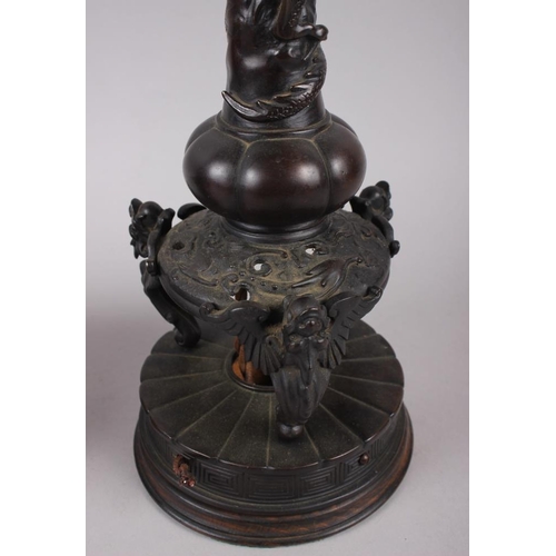 104 - A pair of Chinese bronze table lamps with relief dragon decoration, on circular bases, 17 1/2