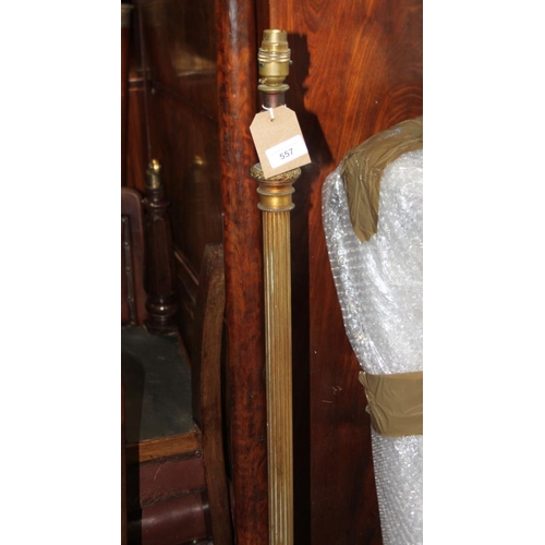 557 - A brass standard lamp with reeded column and three paw feet, 52