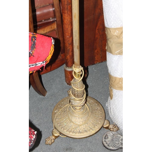 557 - A brass standard lamp with reeded column and three paw feet, 52