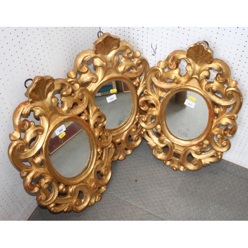 584 - A set of three oval wall mirrors, in gilt frames with open scrollwork decoration, 23