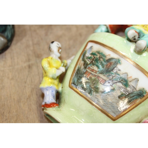 73 - A Chinese polychrome decorated figure of a man holding a sword, a green glazed wall pocket with reli... 